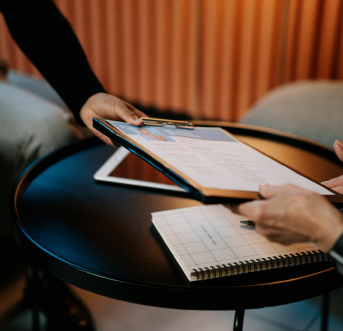 Professional handing over a clipboard during formal onboarding and culture integration.