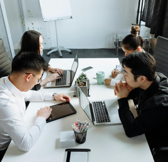 Professional team collaborating on laptop to post jobs and leverage referrals.