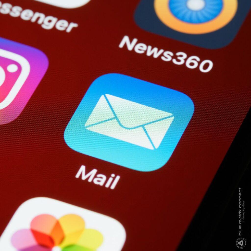 Close-up of a smartphone screen showing email app icon, representing digital email marketing tools.