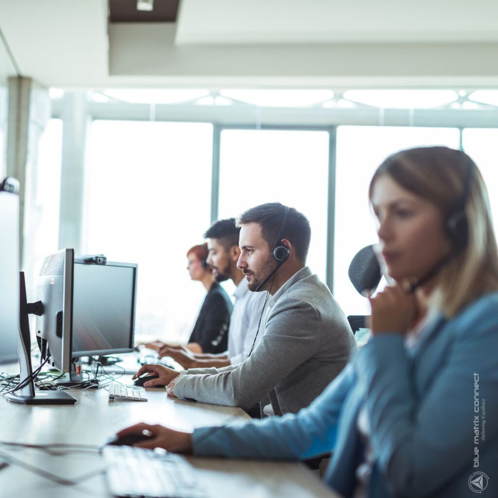 Customer support team working with headsets in an office