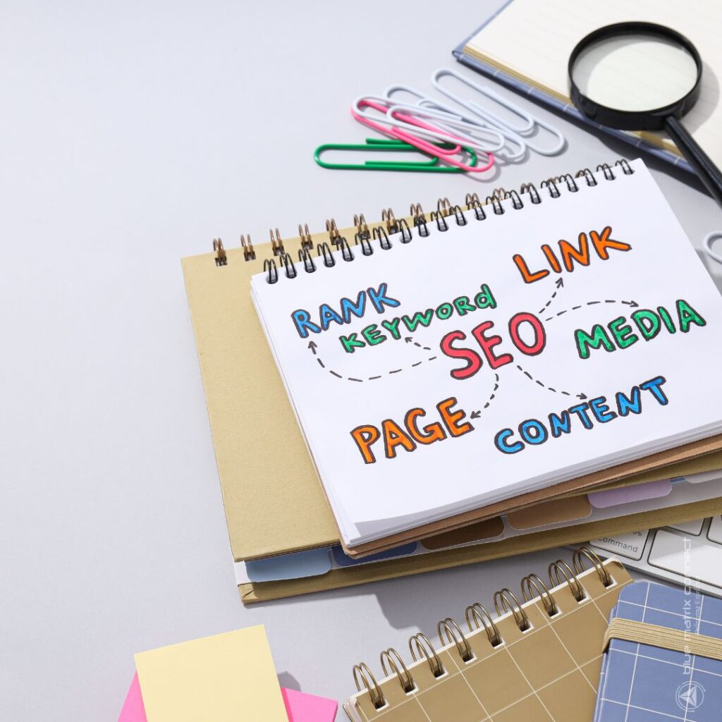 Notepad with SEO strategy keywords like 'Rank', 'Link', 'Page', and 'Content', placed alongside office stationery, symbolizing long-term digital marketing planning.