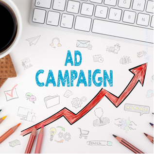 Illustration showing the words 'Ad Campaign' with a red upward-trending arrow, placed on a desk with a keyboard, pencils, and a coffee cup.
